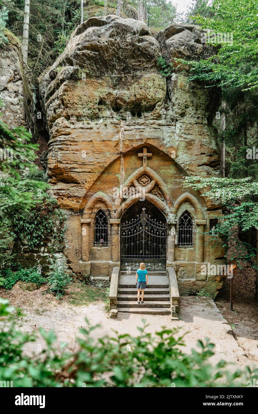 Femme voyageur dans la vallée de la prière, Modlivy dul, avec chapelle sculptée dans rock.Deep vallée rocheuse couverte de forêt et de rochers de grès près de Svojkov Banque D'Images