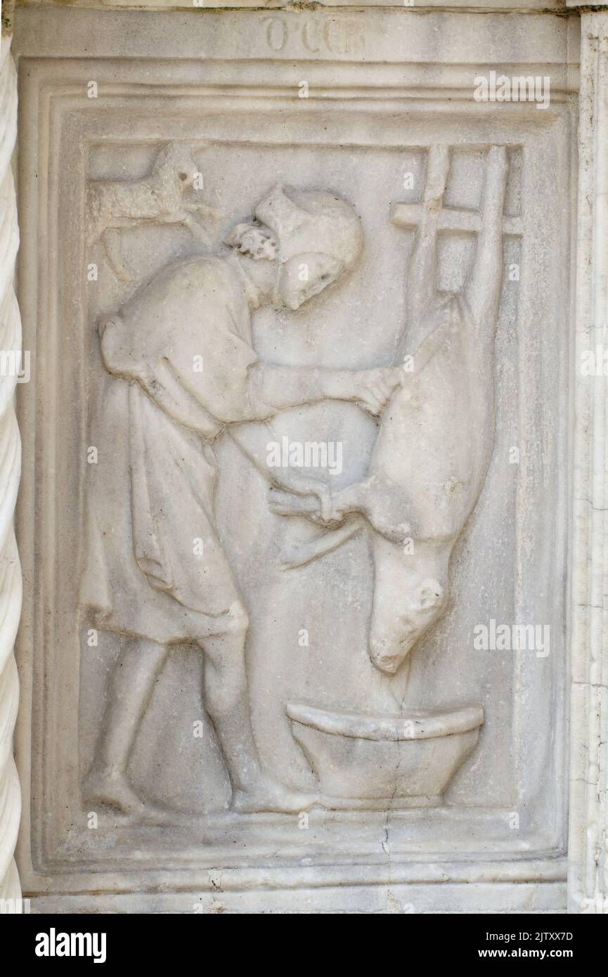 Décembre : l'abattage du porc - détail de Fontana Maggiore (1275), un chef-d'œuvre de sculpture médiévale symbole de la ville de Pérouse - Italie Banque D'Images