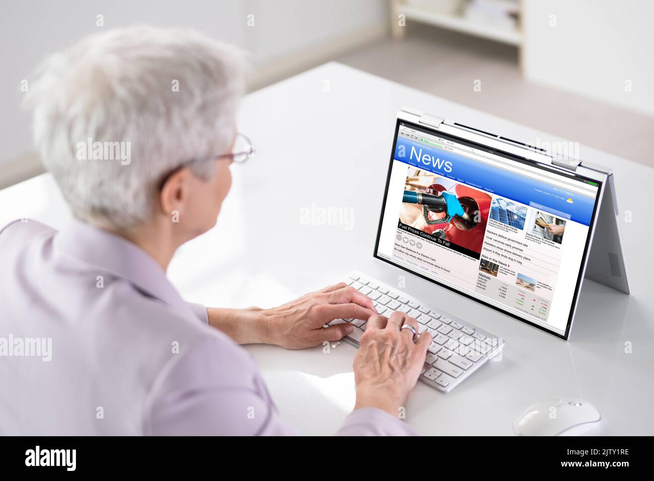 Lire les médias d'information en ligne sur un ordinateur portable convertible Banque D'Images