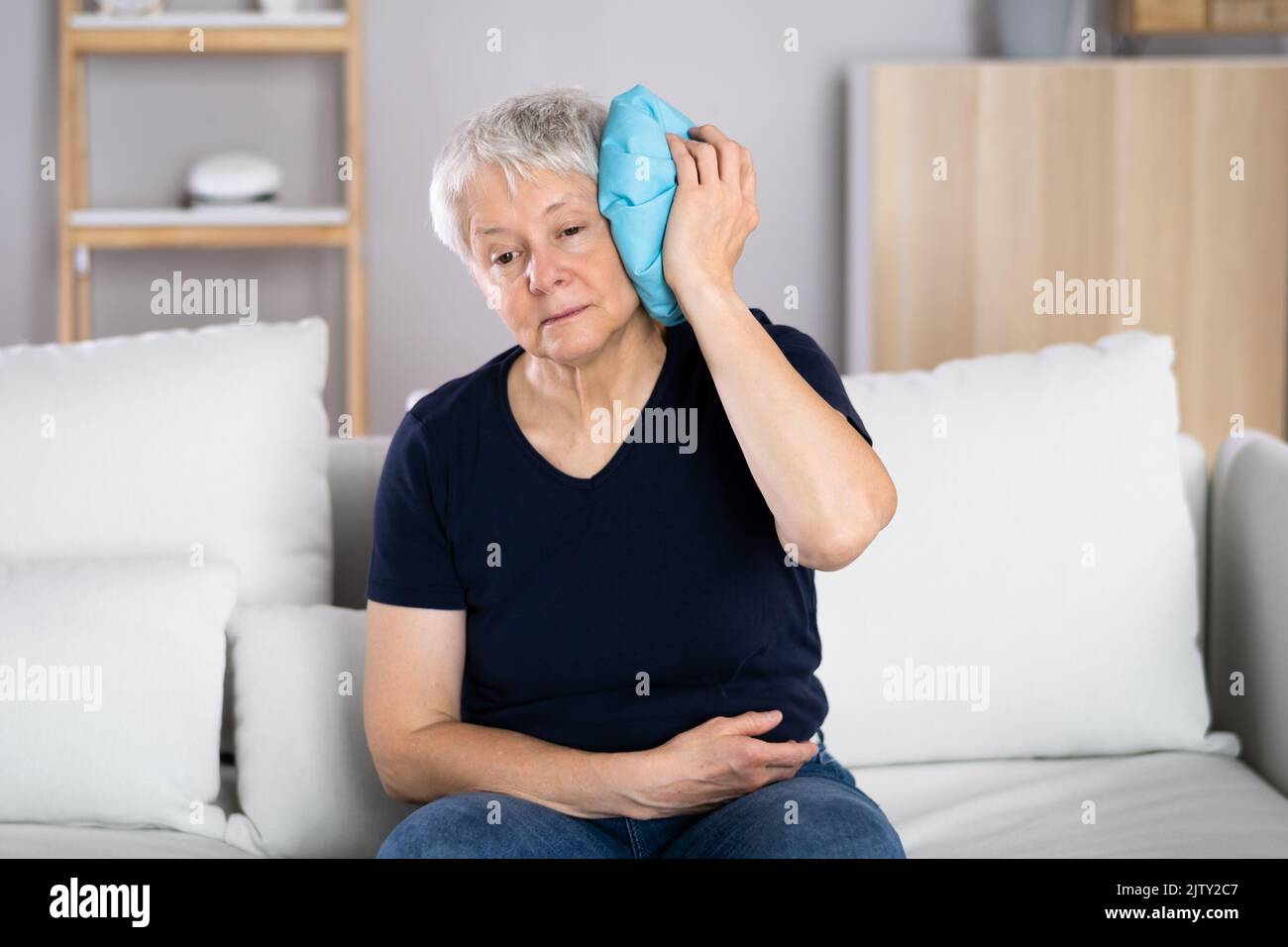 Main de femme appliquant le gel glacé Pack sur la tête Banque D'Images