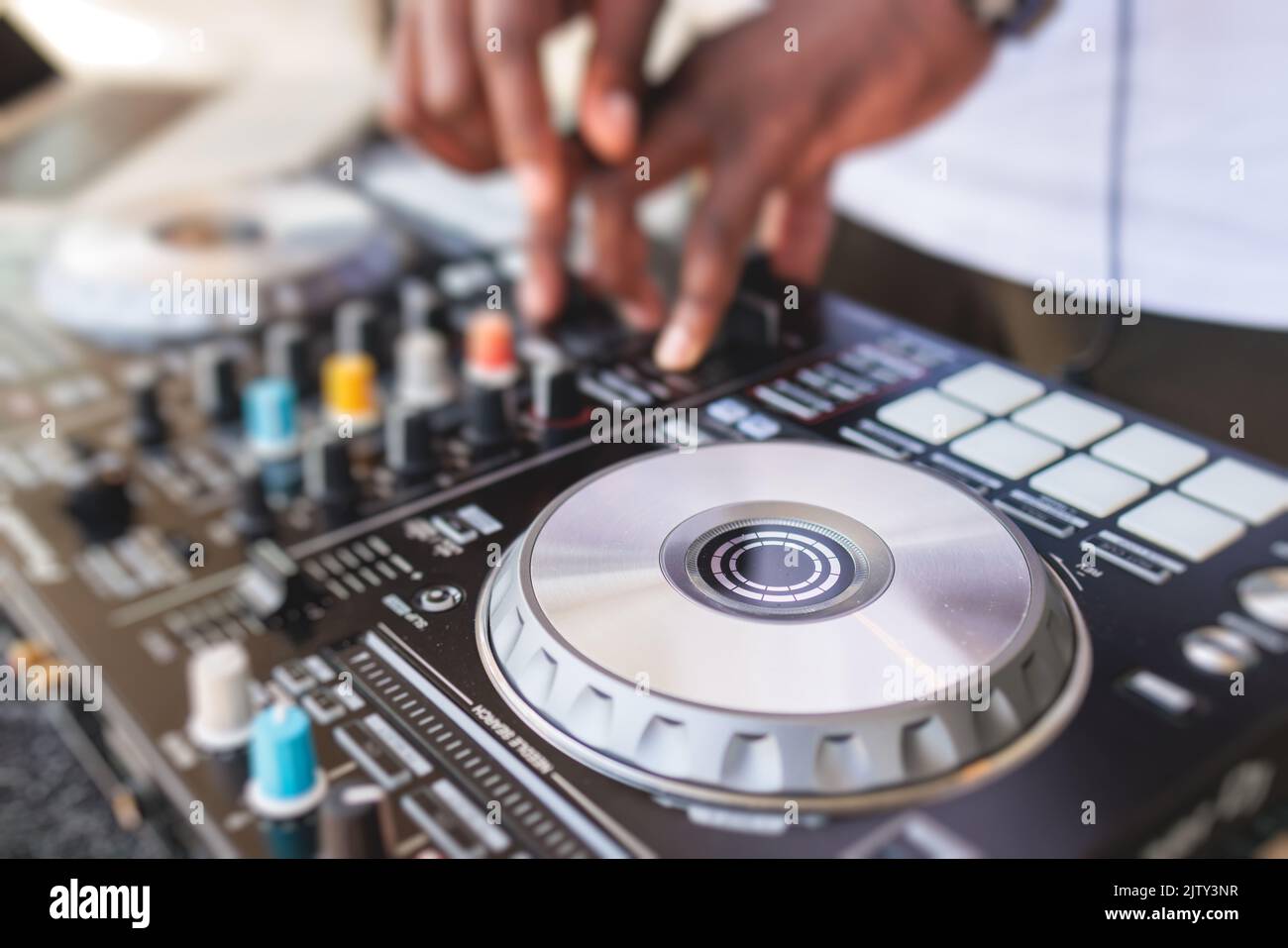 Vue de DJ mixer et plaque en vinyle avec écouteurs sur une table avec DJ  afro-américain jouant sur scène et mélange la piste en arrière-plan,  pendant su Photo Stock - Alamy