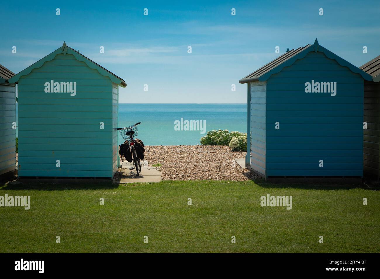 Vieux vélo se penchant contre des cabanes de plage lors d'une journée d'été à Littlehampton, West Sussex Banque D'Images