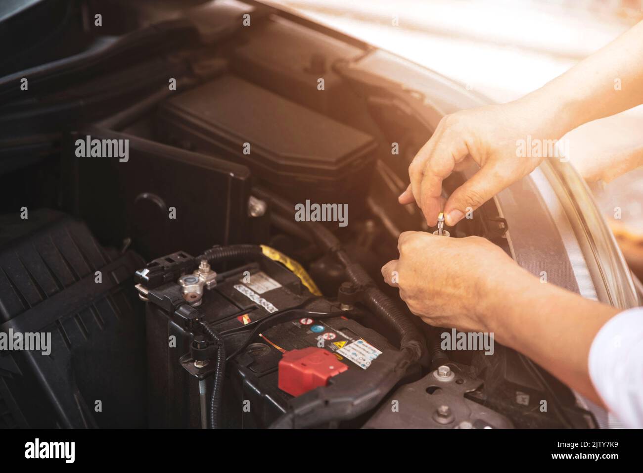 Mains du mécanicien de voiture travaillant à vérifier le moteur de voiture dans le centre de réparation automobile Banque D'Images