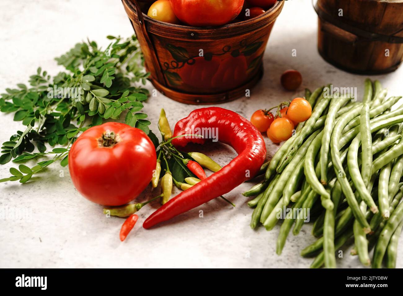 Encore la vie de légumes frais de la maison cerises tomates haricots verts poivron rouge piments okra et feuilles de moringa Banque D'Images