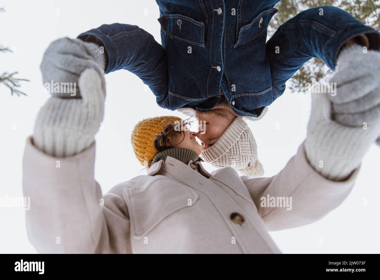 un couple souriant se tient entre les mains dans un parc hivernal Banque D'Images