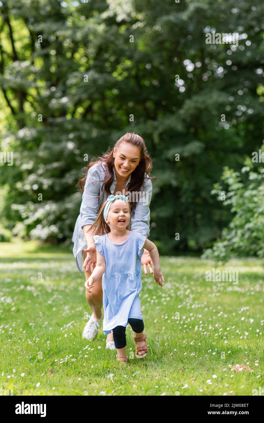 mère heureuse avec petite fille jouant au parc Banque D'Images