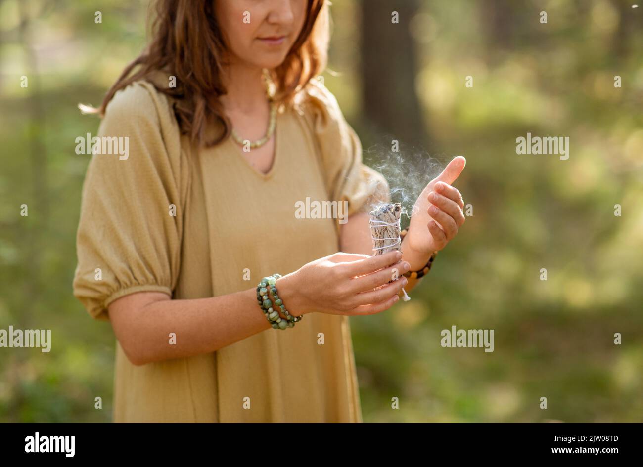 femme avec sage réalisant le rituel magique en forêt Banque D'Images