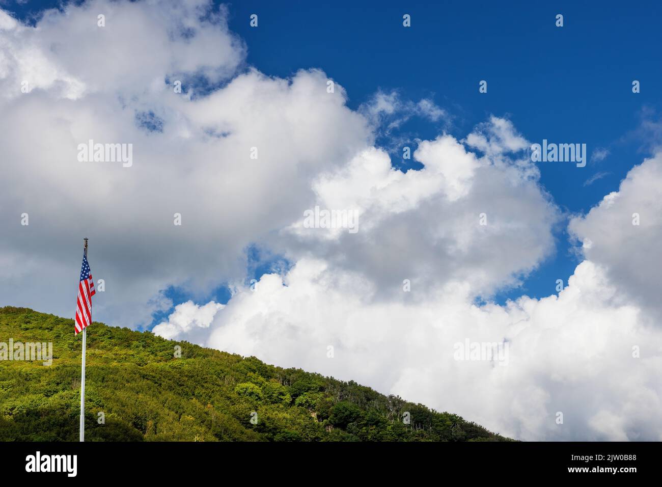 Un Flay des États-Unis est suspendu d'un poteau sous un ciel nuageux en face d'une colline en Caroline du Nord Banque D'Images