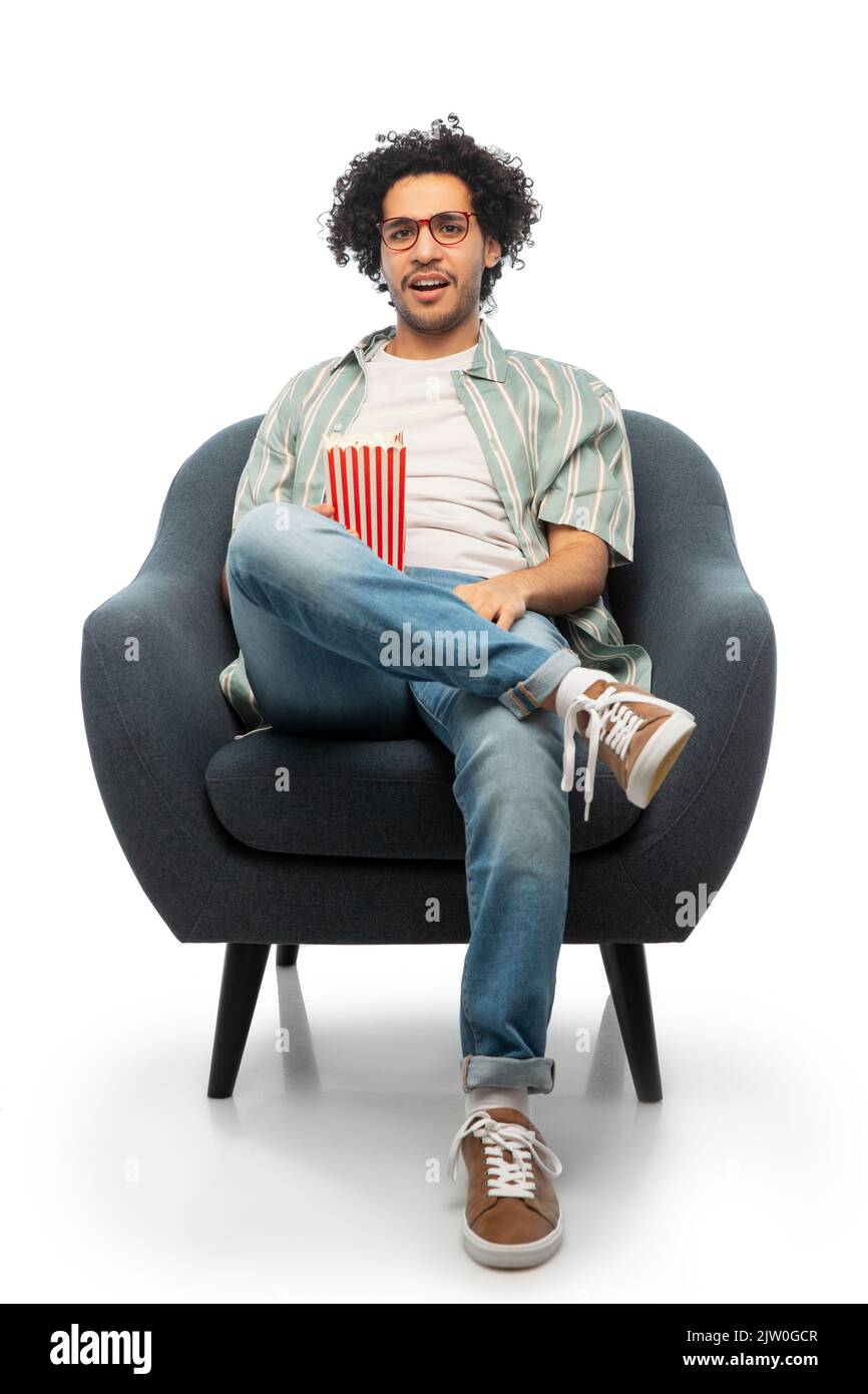 homme avec pop-corn regardant le film assis sur une chaise Banque D'Images
