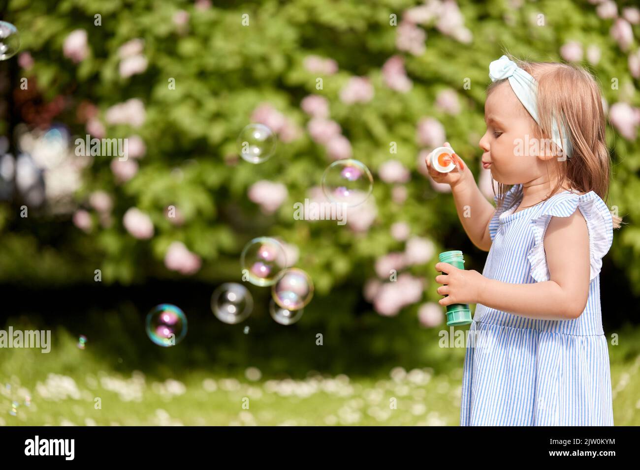 petite fille soufflant des bulles de savon dans le parc ou le jardin Banque D'Images