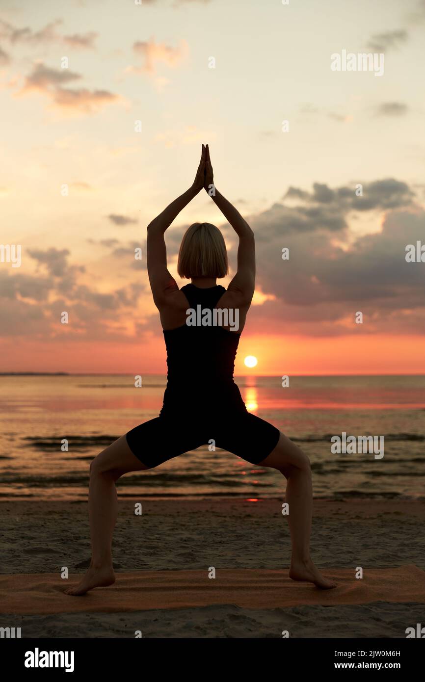femme faisant la déesse de yoga pose sur la plage Banque D'Images