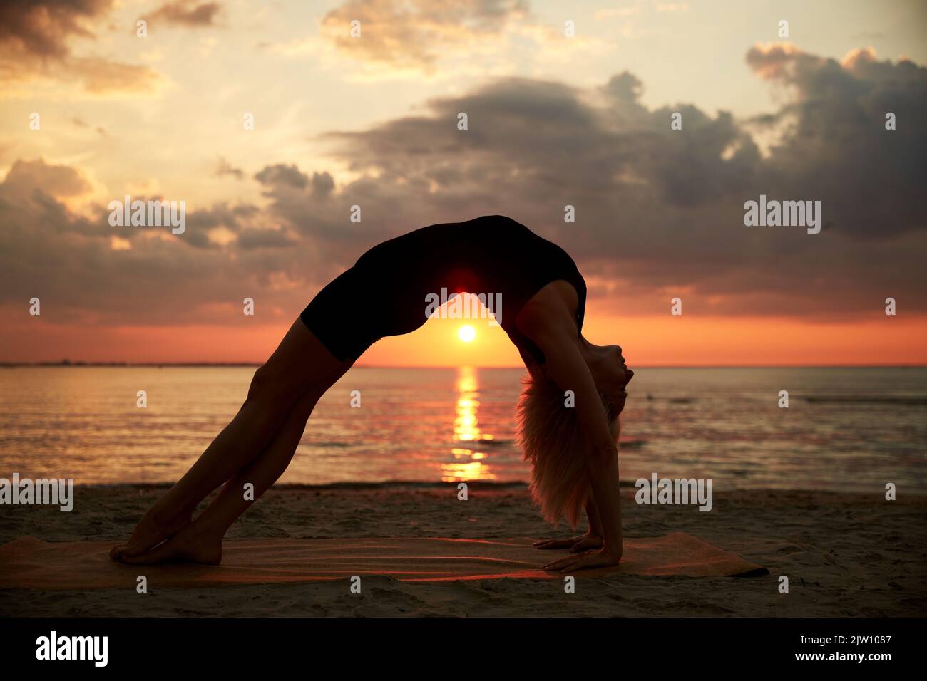 femme faisant le pont de yoga pose sur la plage Banque D'Images