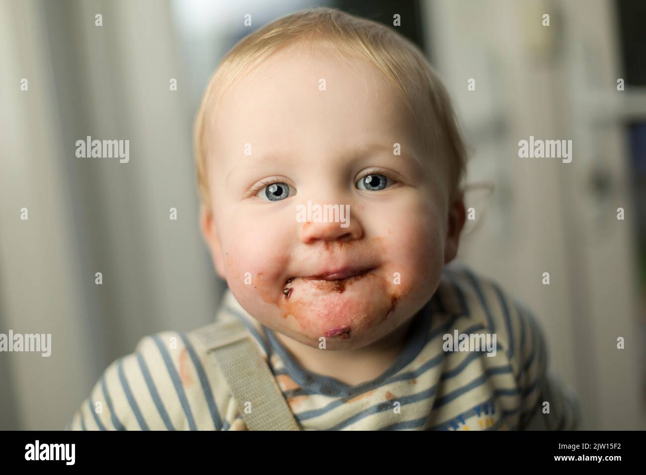 Un homme de race blanche tout-petit, dont la bouche est désordonnée par la consommation de crème glacée, regarde dans l'appareil photo. Banque D'Images