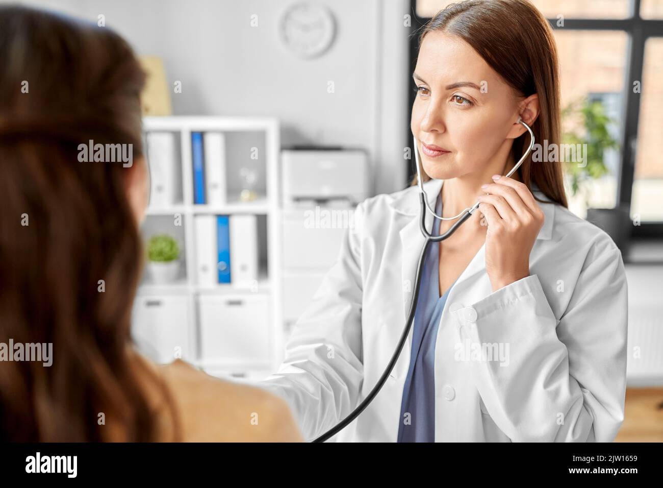 médecin avec stéthoscope et femme à l'hôpital Banque D'Images