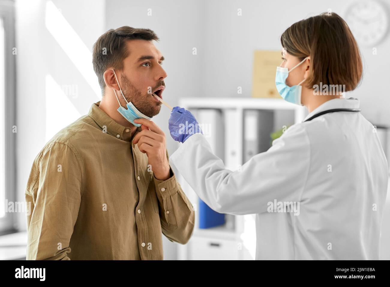 médecin vérifiant la gorge du patient mâle à l'hôpital Banque D'Images
