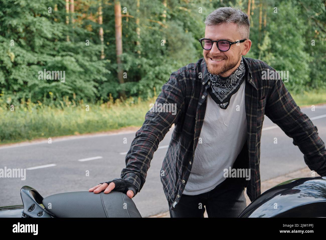 Motard Homme Motocycliste D'âge Moyen Souriant Assis Avec Une Moto