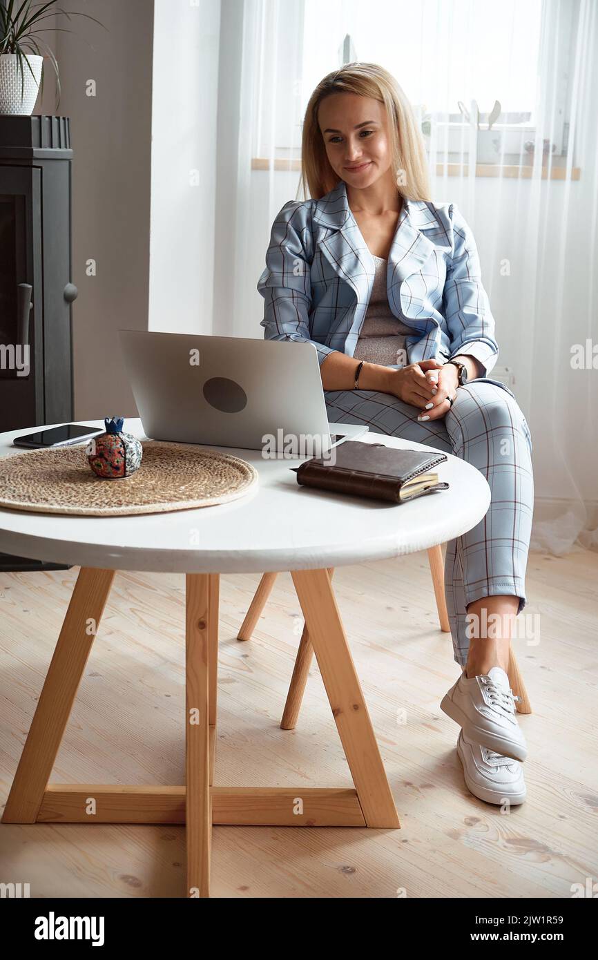 Jeune femme utilisant un ordinateur portable et tenant une conférence en ligne, travail à distance à la maison Banque D'Images