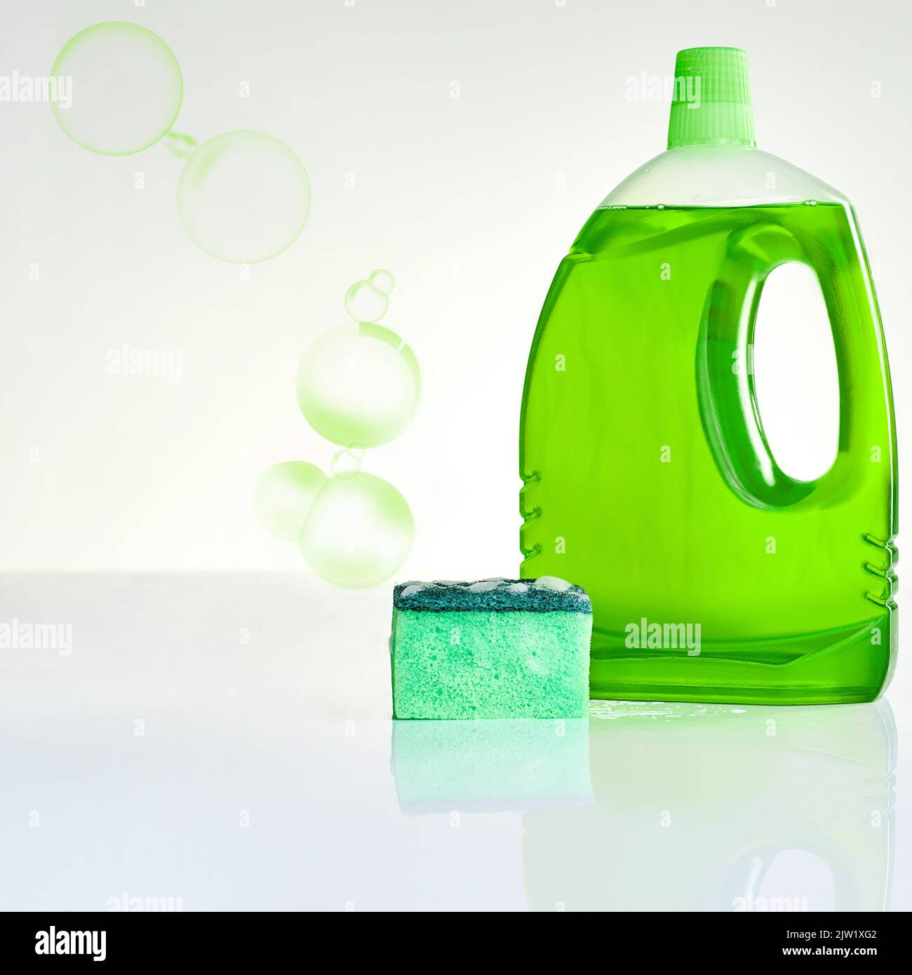 Pour les surfaces propres et grinçantes. Photo studio d'une bouteille de détergent à vaisselle et d'une éponge sur fond gris. Banque D'Images