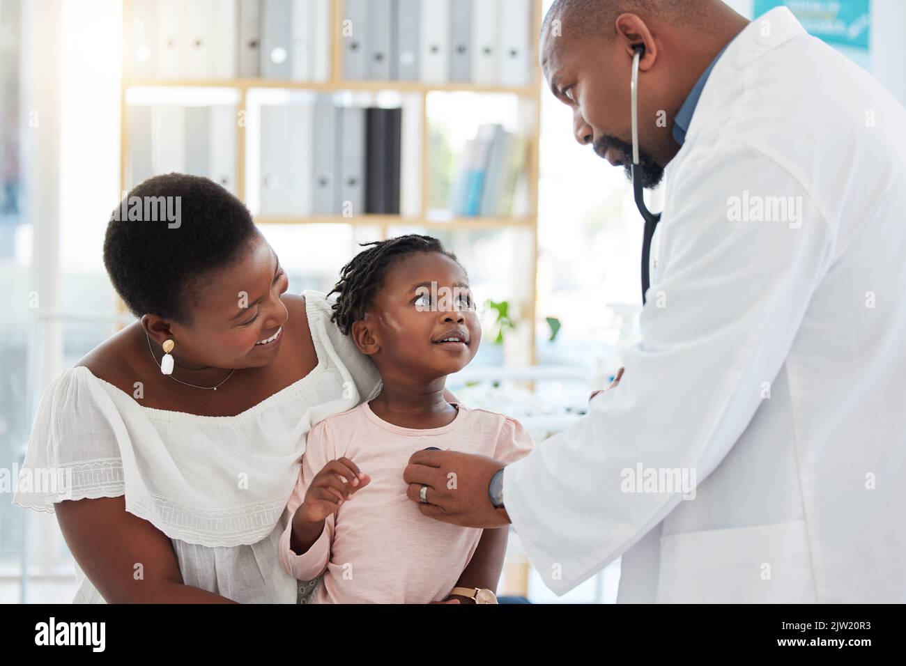 Médecin de coeur, mère et enfant à l'hôpital pour un examen ou un conseil médical à une clinique. Homme de santé noir en cardiologie Banque D'Images