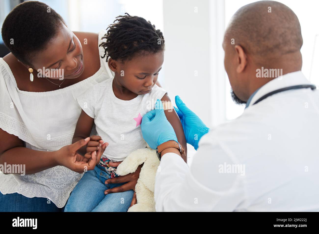 Aide-bande, vaccin covid ou famille avec médecin à l'hôpital, soins de santé ou chambre médicale pour enfants. Fille, mère ou pédiatre travailleur et plâtre pour Banque D'Images