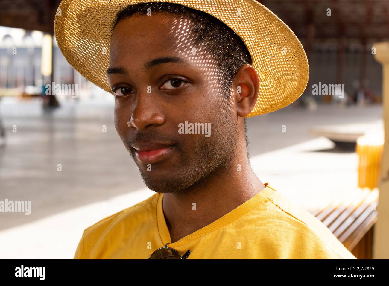 Un homme afro-espagnol portant des vêtements décontractés avec un chapeau et des lunettes de soleil Banque D'Images