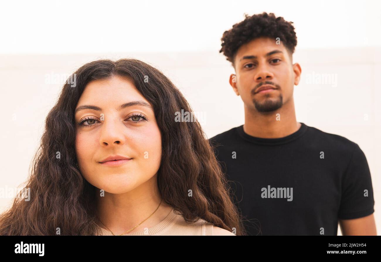 Vue avant du couple multiracial regardant la caméra Banque D'Images