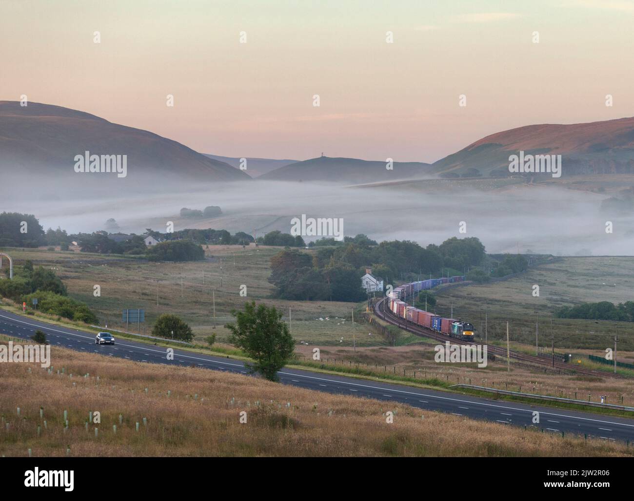 DRS classe 88 locomotive électrique transportant un train de marchandises tôt le matin dans la brume à la campagne sur la ligne principale de la côte ouest à Cumbria Banque D'Images