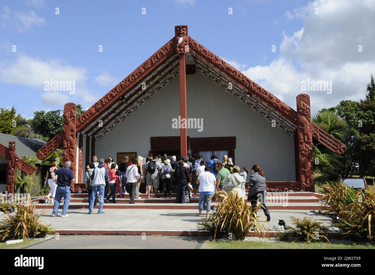 Les visiteurs se rassemblent pour entrer dans la Wharenui (Maori Meeting House) pour assister à un spectacle de danse, de musique et de chant maoris traditionnels à te Puia Whakarewarewa Banque D'Images