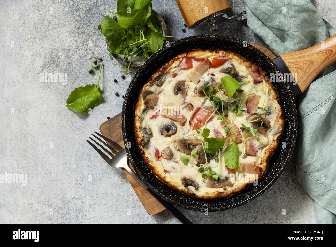 Petit-déjeuner italien. Omelette rustique (frittata) avec champignons et bacon sur une poêle en fonte. Vue de dessus. Copier l'espace. Banque D'Images