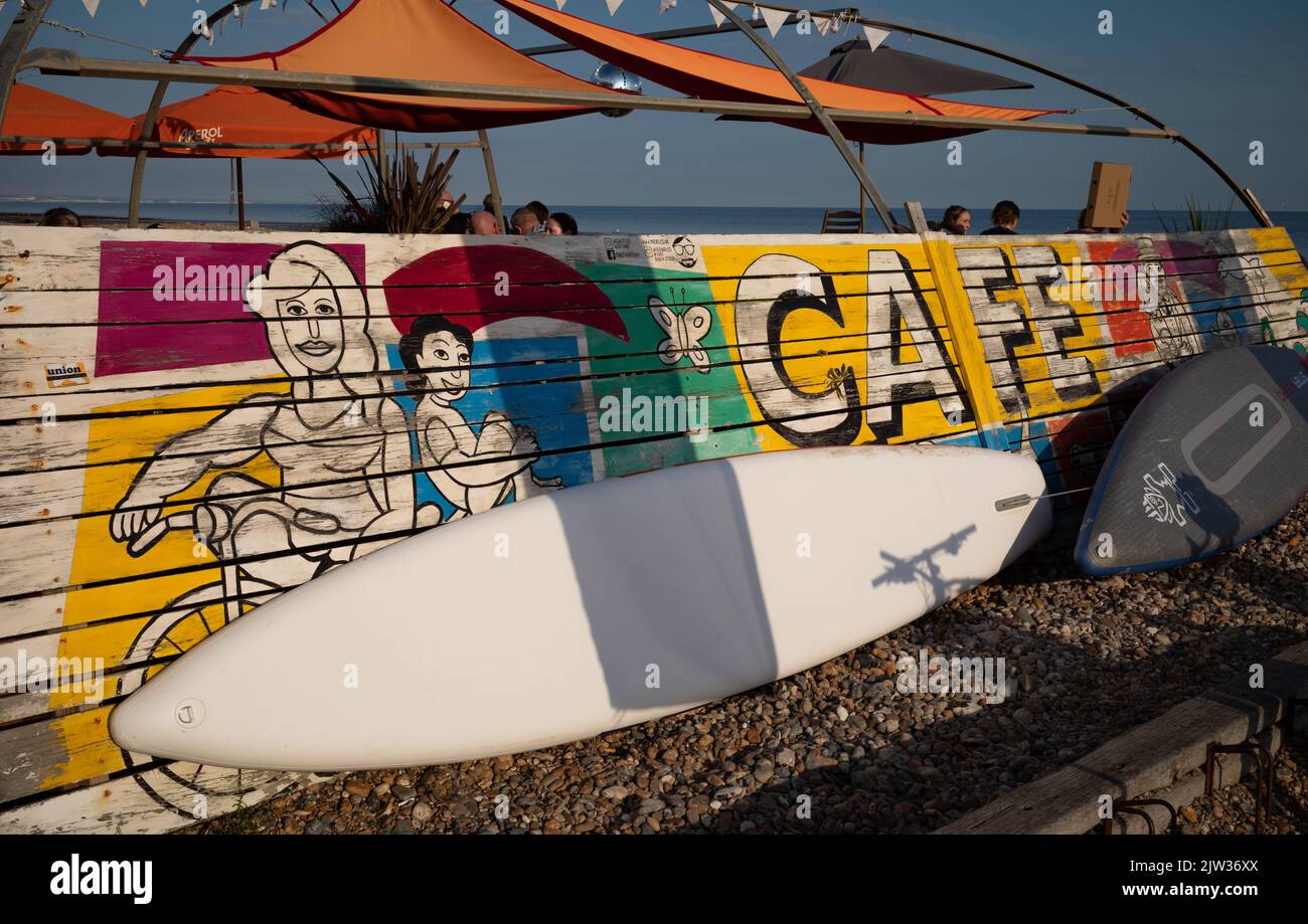 Les planches de surf se trouvent contre les murs peints d'un café sur la plage de Worthing, West Sussex, Royaume-Uni. Banque D'Images