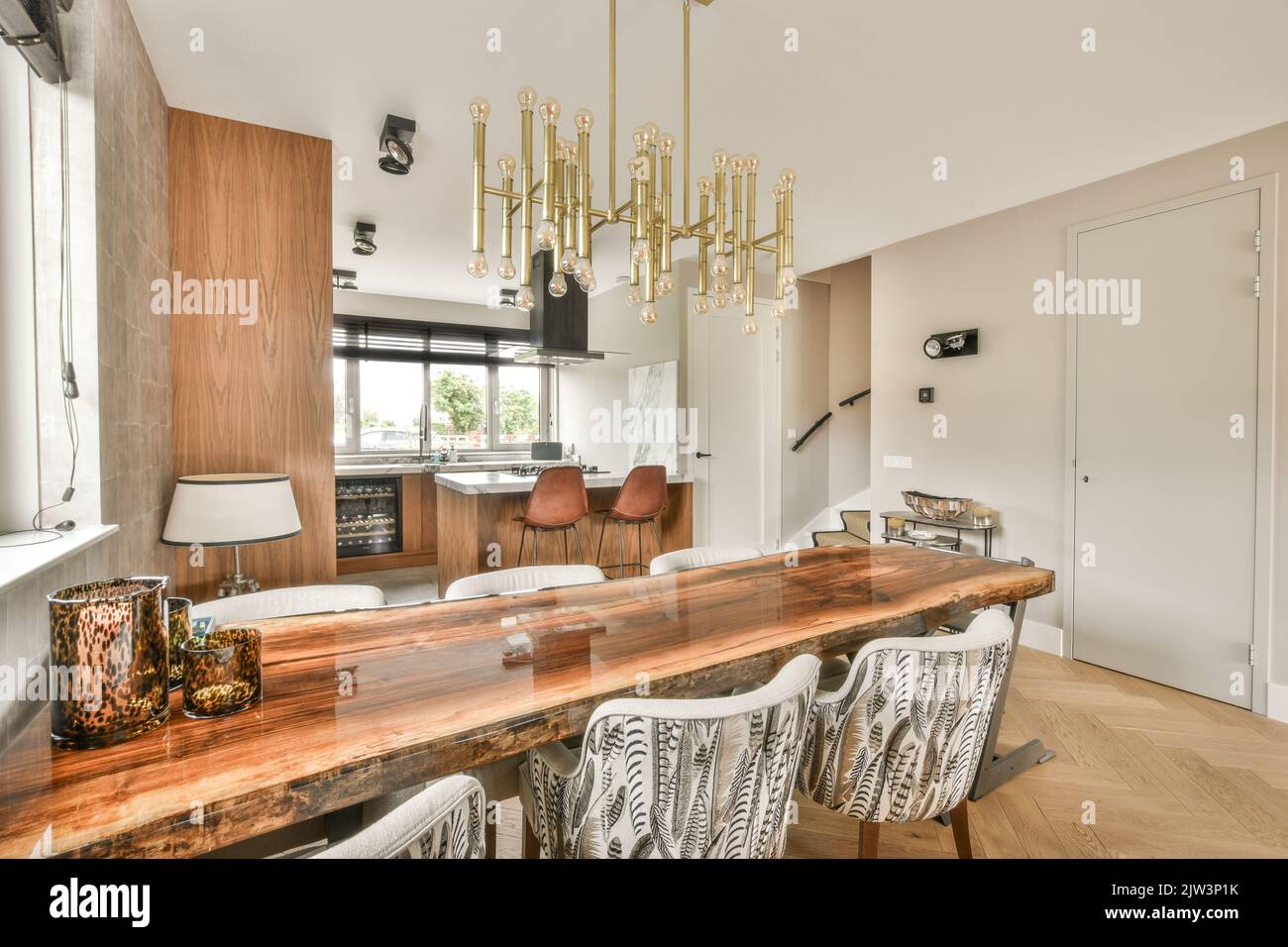 Intérieur d'une cuisine lumineuse et d'une salle à manger avec portes-fenêtres dans un appartement contemporain en journée Banque D'Images