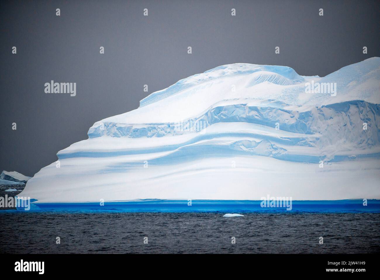 Grand iceberg et ciel moody Portal point Antarctique Peninsula Antarctique. Fusion des pôles. L'Antarctique est le continent qui souffre le plus de la mondialisation Banque D'Images