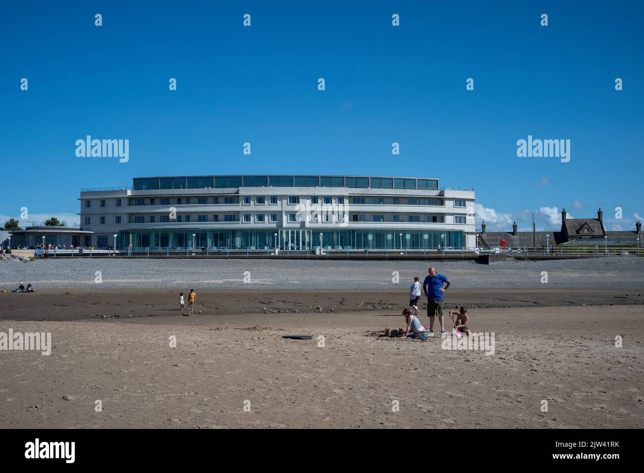 Construction de châteaux de sable à l'extérieur de l'emblématique Art Deco Midland Hotel, Morecambe Bay, Lancashire, Royaume-Uni Banque D'Images