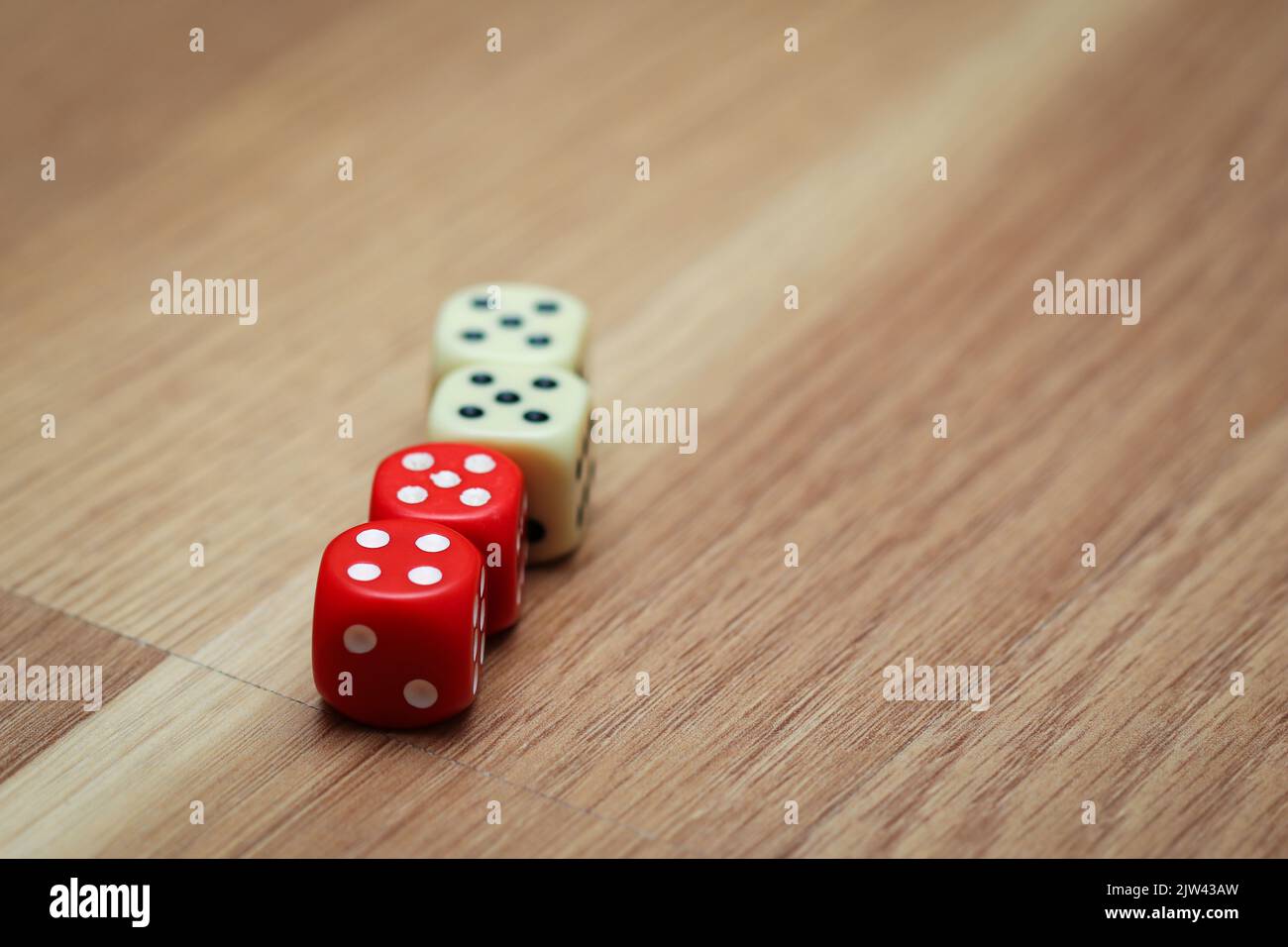 Quatre dés de jeu rouges et blancs sur le sol avec les numéros cinq et quatre Banque D'Images