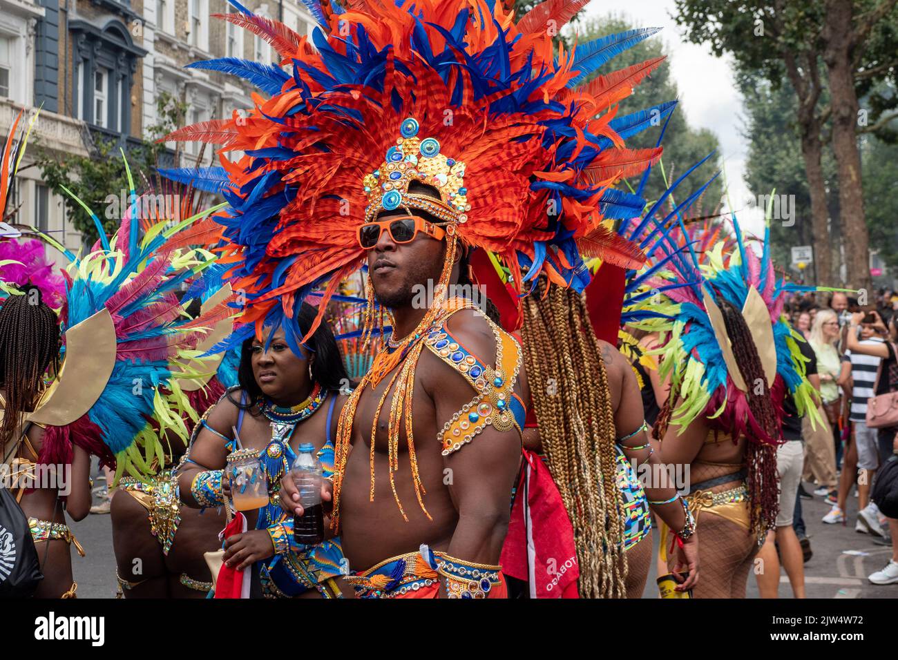 Londres, Angleterre, Royaume-Uni - 29 août 2022: Un jeune homme habillé pour le carnaval avec des plumes colorées dans les rues, à Notting Hill Banque D'Images