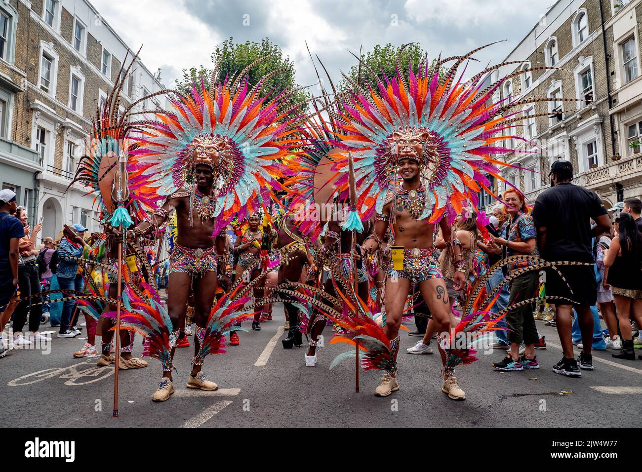 Londres, Angleterre, Royaume-Uni - 29 août 2022: Jeune groupe d'Africains vêtus pour le carnaval avec des plumes dans différentes couleurs dans les rues, à Notting Hill Banque D'Images