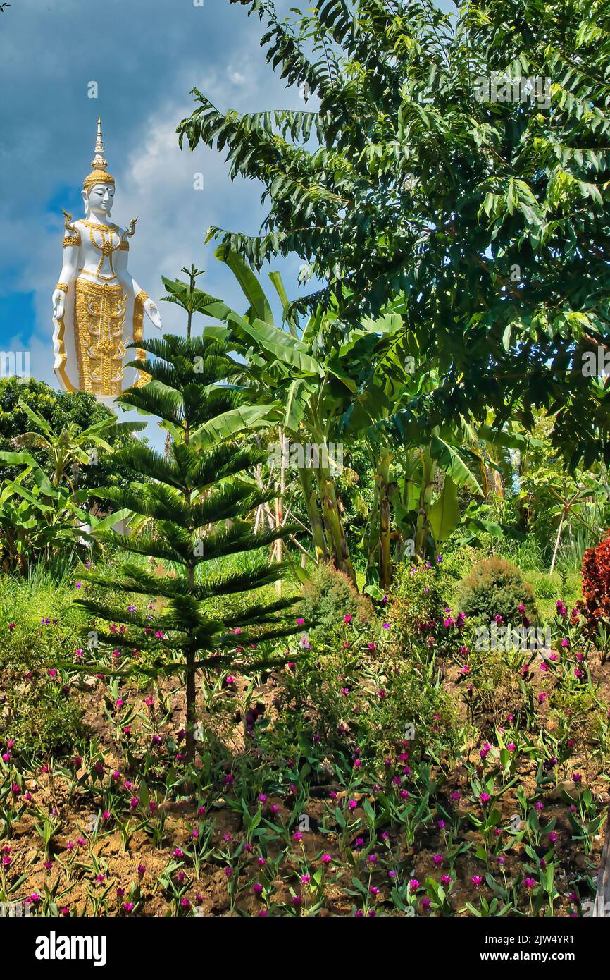 Statue de Bouddha d'or et blanc dans un jardin tropical au-dessus du canyon Nam Nao, province de Phetchabun, Thaïlande Banque D'Images