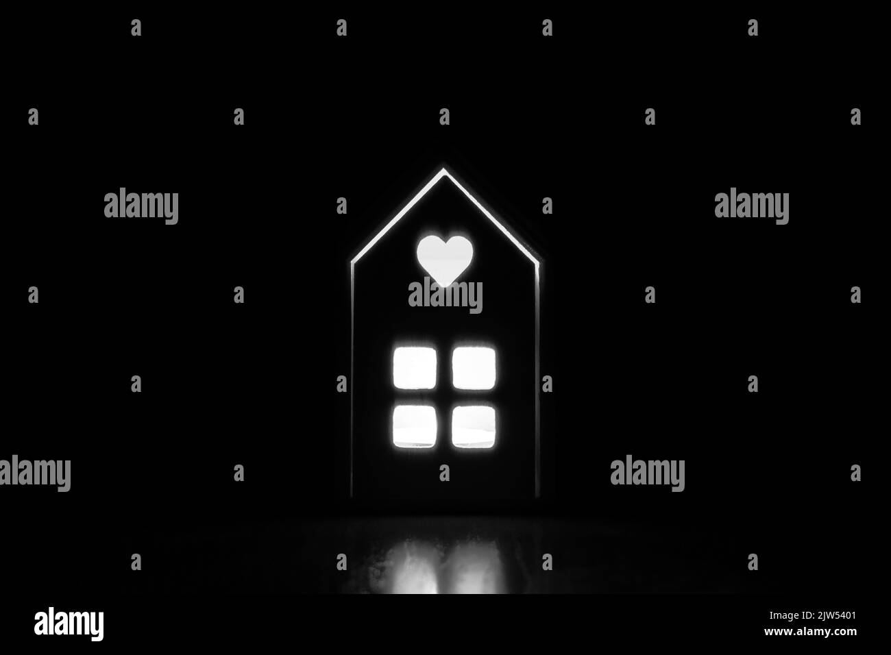 Une petite maison en bois dans l'obscurité avec une lumière dans la fenêtre, lumière dans la fenêtre de la maison Banque D'Images