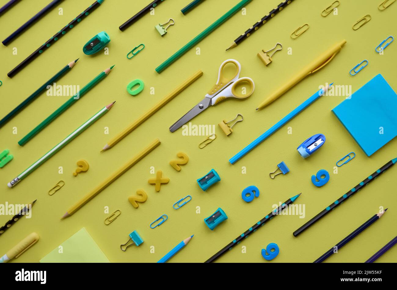 Articles de papeterie pour l'école en diagonale sur fond jaune, platlay. Banque D'Images