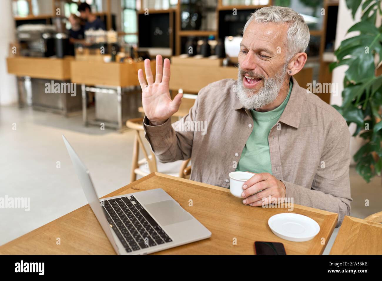 Un homme d'affaires plus âgé qui se contente d'utiliser un ordinateur portable pour travailler à distance par appel vidéo. Banque D'Images
