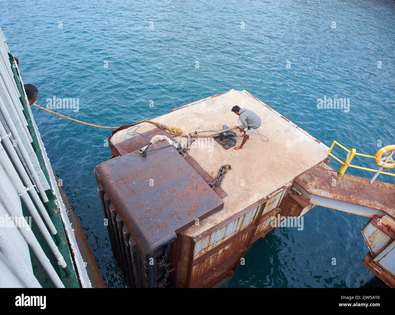 Un officier de port retire la corde d'ancrage d'un ferry au port de Ketapang qui naviguera jusqu'à l'île de Bali Banque D'Images