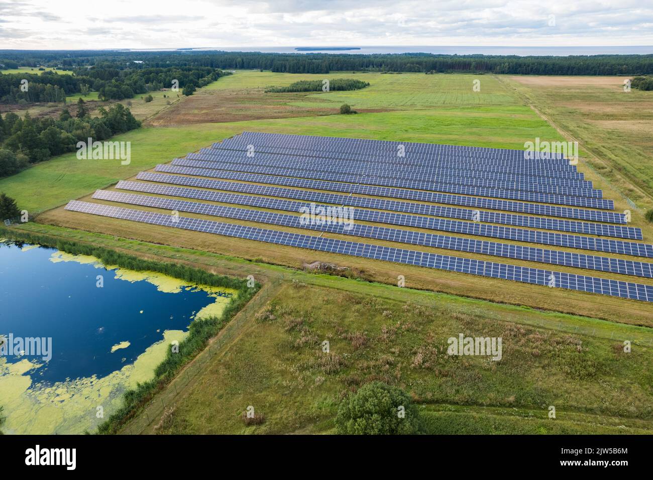 Vue aérienne des panneaux solaires sur un champ d'herbe verte. Source d'énergie alternative. Banque D'Images