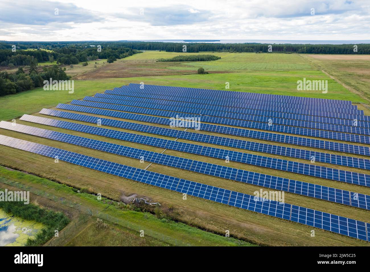 Vue aérienne des panneaux solaires sur un champ d'herbe verte. Source d'énergie alternative. Banque D'Images