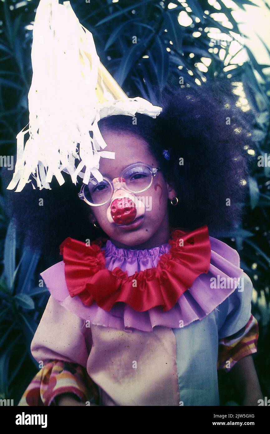 Enfant afro-caribéen déguisé en clown à la fin de 70s Banque D'Images