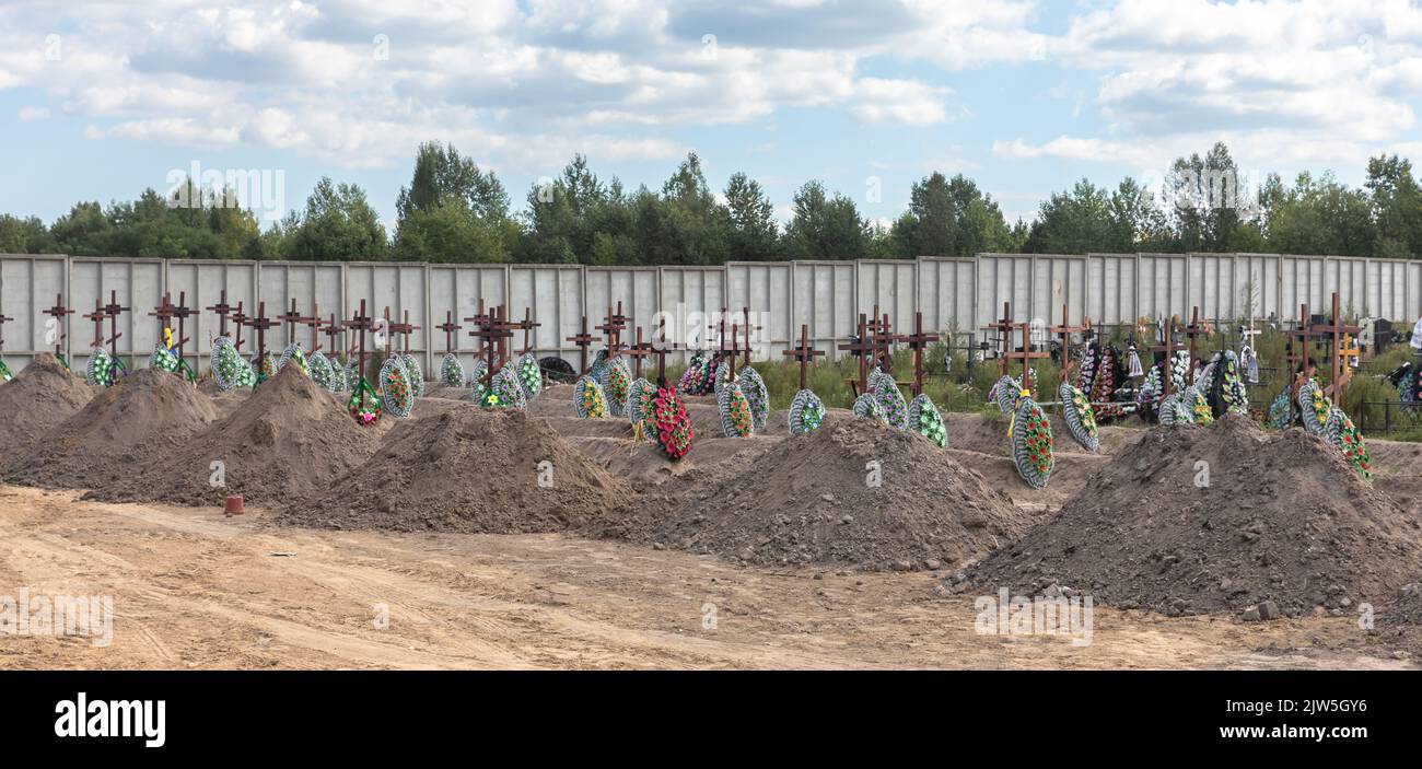 Tombes fraîchement creusées vues au cimetière de Bucha. Coffins contenant les corps de personnes non identifiées tuées dans le district de Bucha au moment de l'occupation russe, lors d'une cérémonie d'enterrement dans un cimetière de Bucha, région de Kiev, Ukraine. Des mois après le retrait des forces russes du district de Bucha, les corps qui n'ont pas été identifiés ont été enterrés et marqués de numéros dans un cimetière de Bucha. Banque D'Images