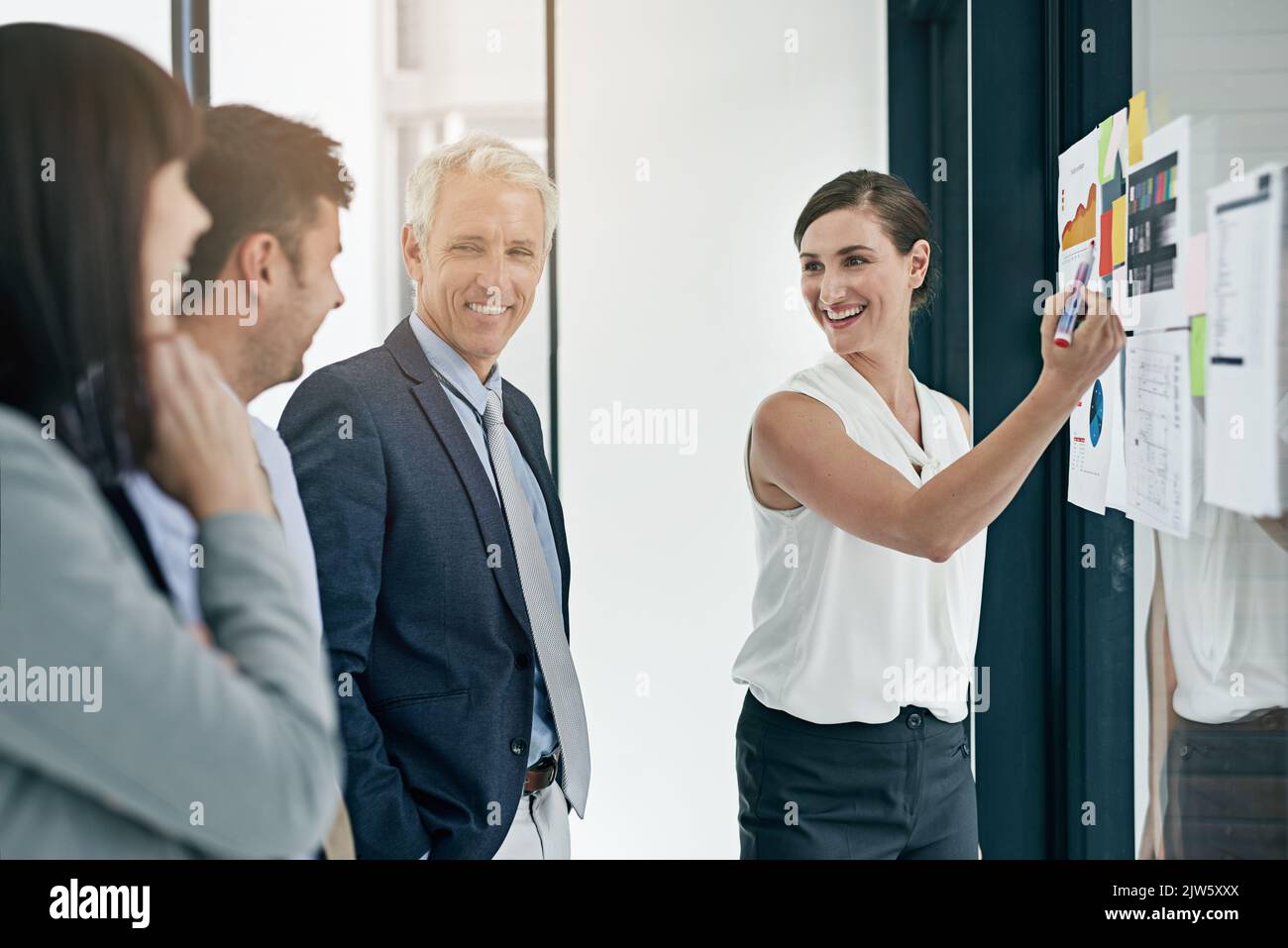 Ils sont tous d'accord avec les plans d'affaires. Une femme qui donne une présentation à des collègues dans un bureau. Banque D'Images