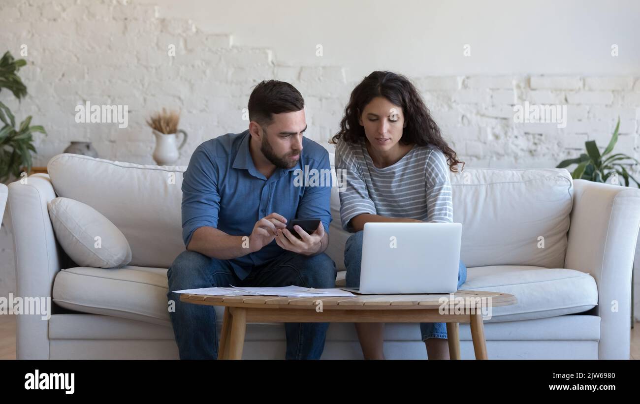 Jeune couple engagé dans le contrôle du budget familial et la gestion financière Banque D'Images