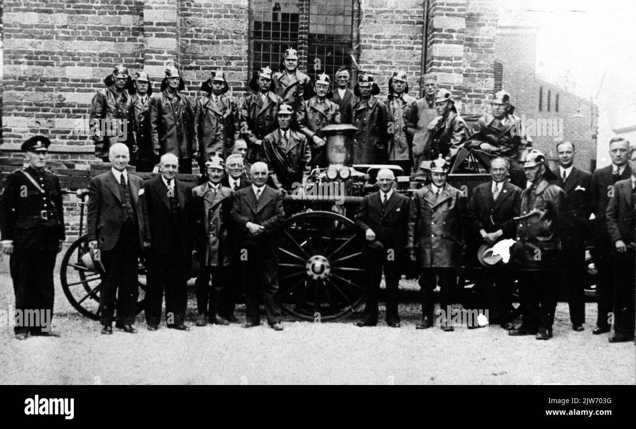 Portrait de groupe de la brigade de pompiers volontaires de la municipalité de Vleuten avec quelques représentants de la municipalité et le jet de vapeur à la tour de l'église N.H. sur Dorpsstraat.n.b. La tour de l'église a servi de place de stationnement pour le pulvérisateur à vapeur. La municipalité de Vleuten est le 1 janvier 1954 incluse dans la municipalité de Vleuten-de Meern; cette municipalité est le 1 janvier 2001 a rejoint la municipalité d'Utrecht. Banque D'Images