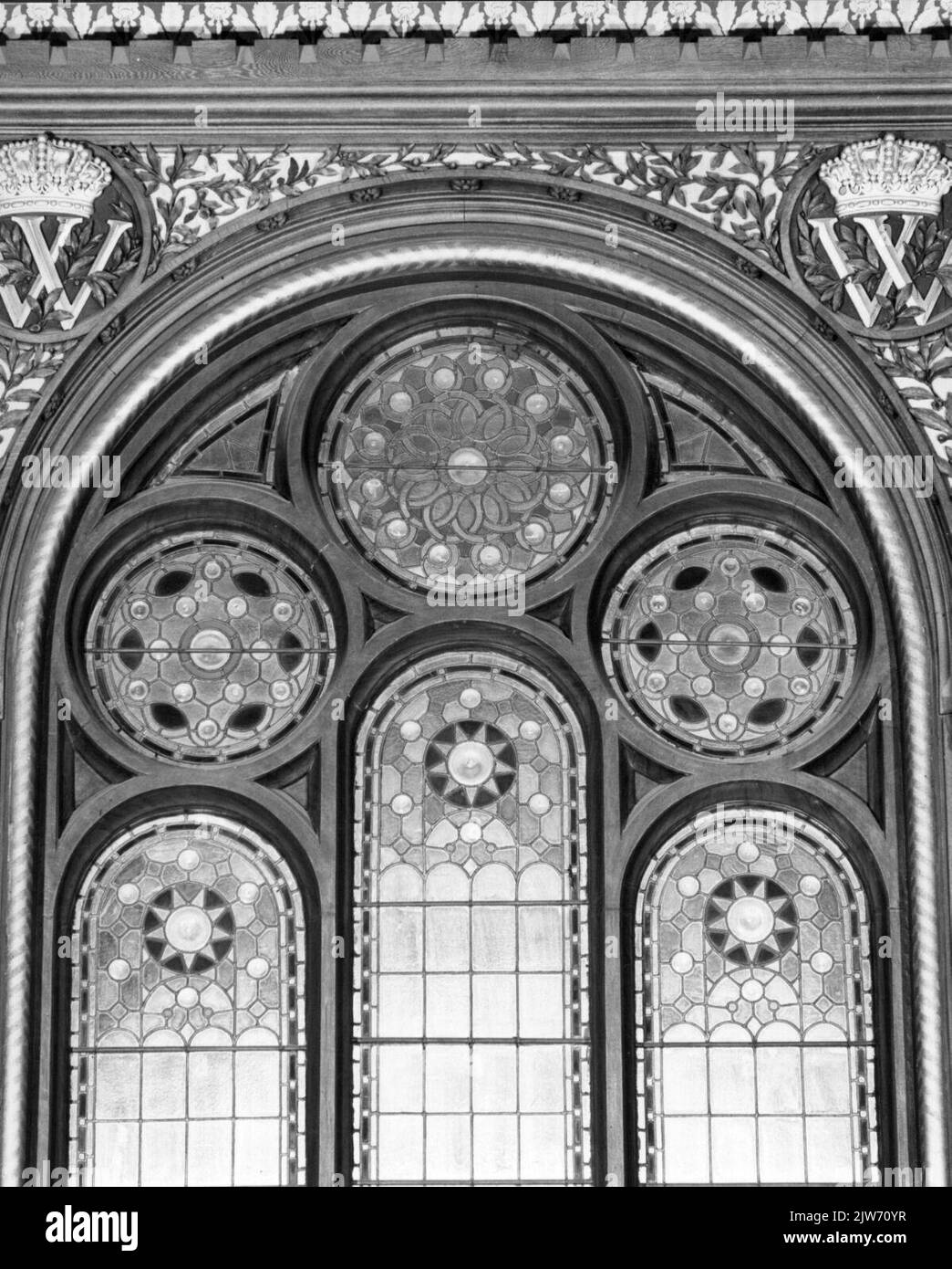 Image du cadre et de la fenêtre en vitraux avec deux W couronné au-dessus des portes de l'escalier dans le pavillon royal de la station N.S. Amsterdam et al. À Amsterdam. Banque D'Images