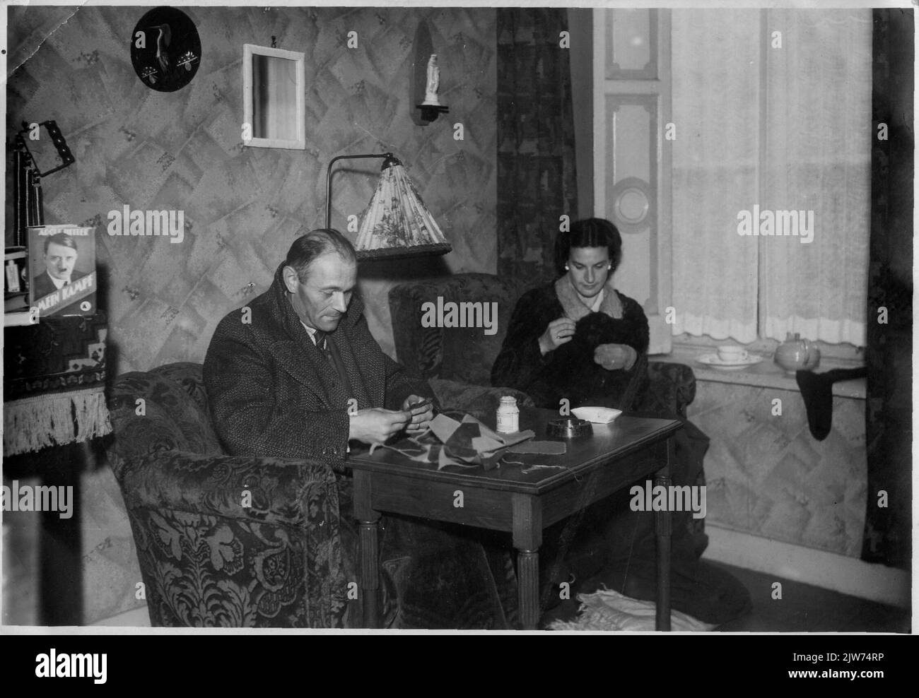 Intérieur de la maison de mw. W.th (Louise) Michels-Driessen (bureau de concierge R.K. Paroissial Arm Board, Donkerstraat 15) à Utrecht avec les gens en cachant Arie van Lemmen (officier de police) et Loek de Groot Rodriguez (violoncelliste Concertgebouw Orchestra). Banque D'Images